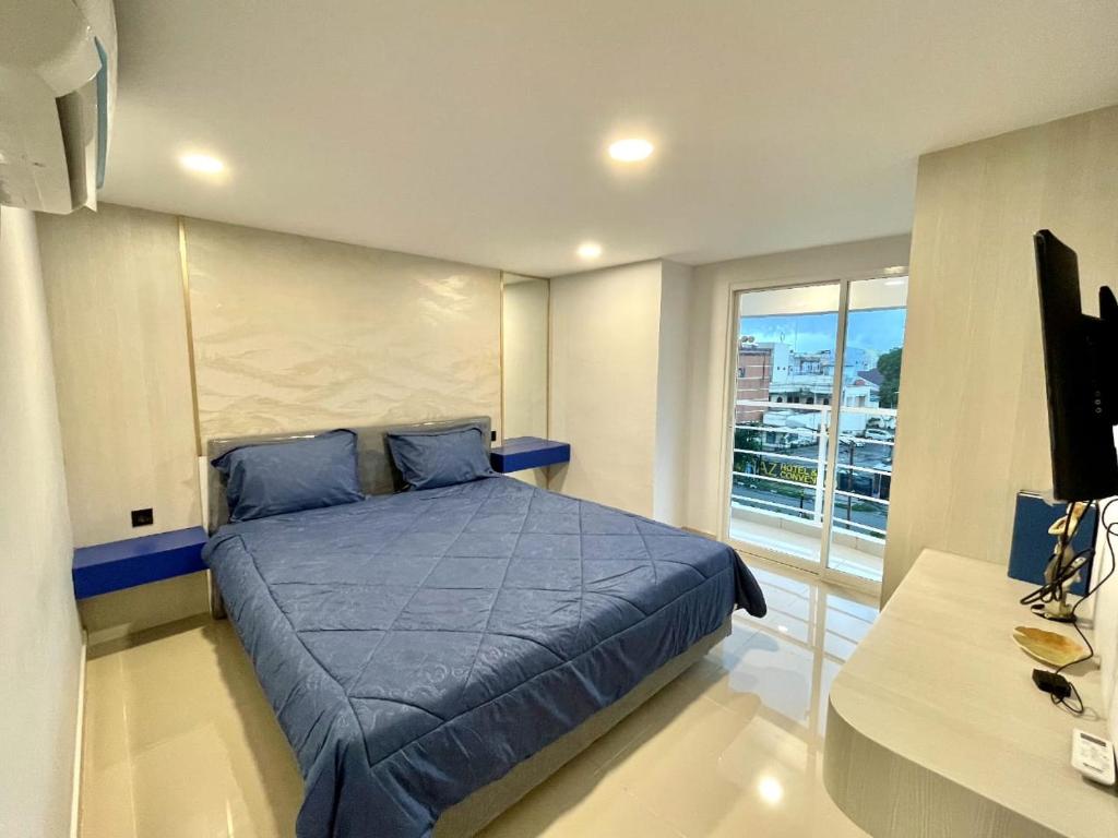 1 dormitorio con cama con sábanas azules y ventana en Alhesa Apartment, en Sunggal