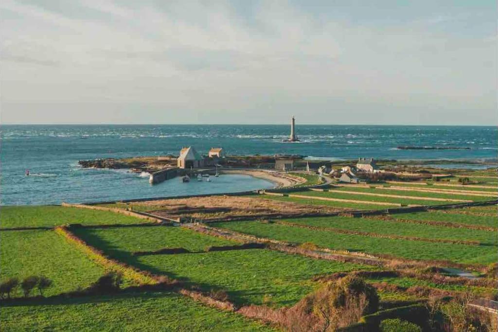 an island in the ocean with a lighthouse in the distance at Jolie maison à la campagne « Chez Germaine » in Digosville