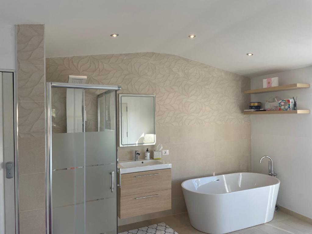 a bathroom with a white tub and a sink at Alojamiento de invitados in Sauzal