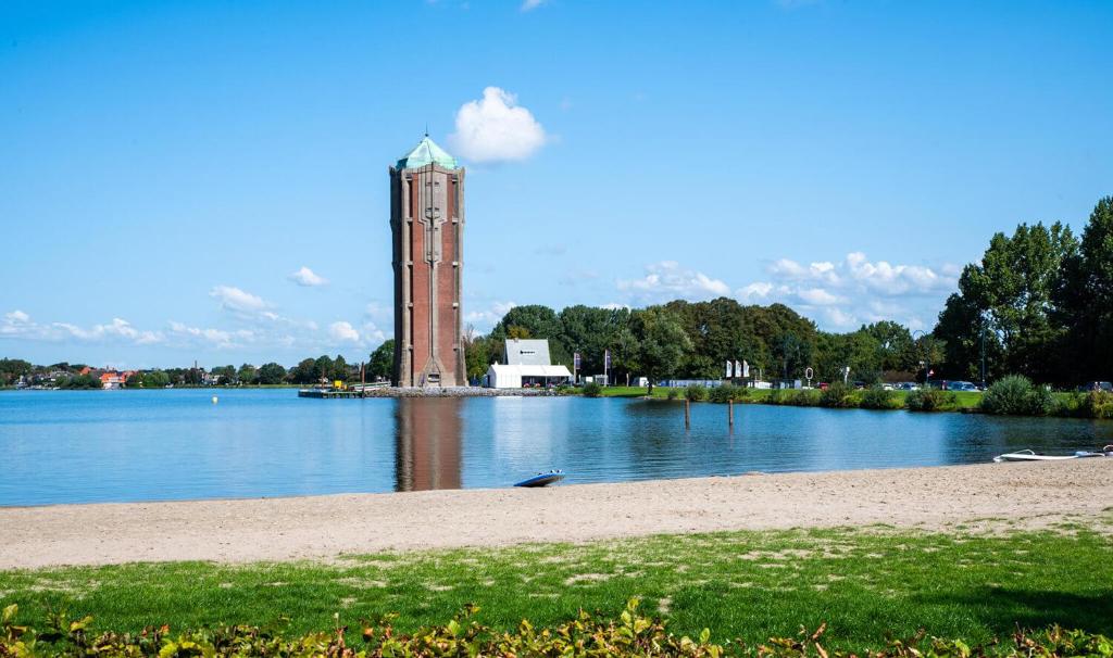 une tour d'horloge au milieu d'une masse d'eau dans l'établissement Tiny House in center Aalsmeer I Close to Schiphol & Amsterdam, à Aalsmeer
