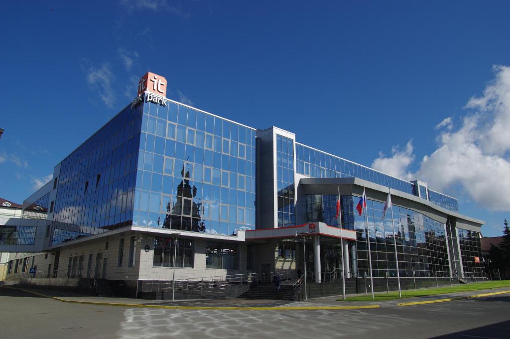 un gran edificio de cristal con una torre de reloj en la parte superior en Business Hotel IT Park, en Kazán