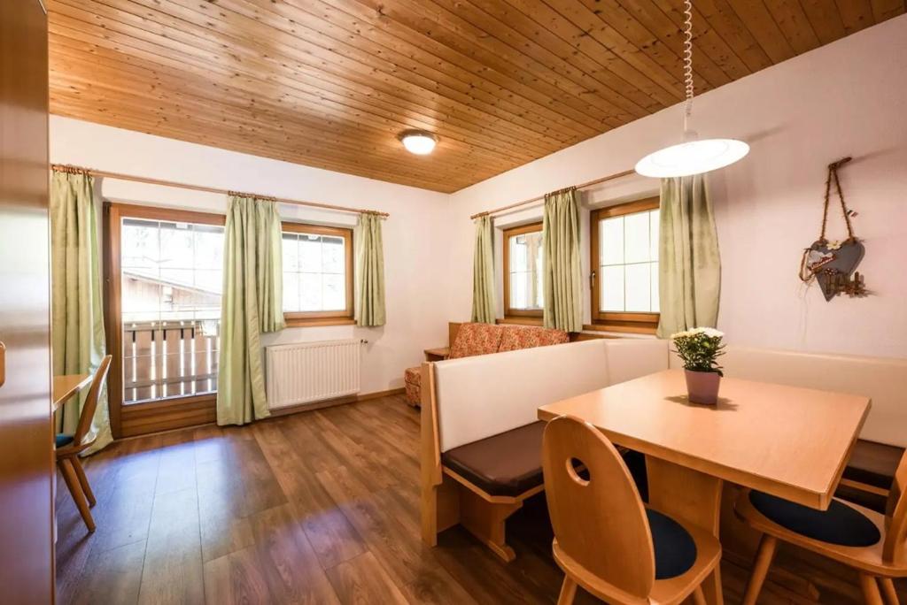 Appartement Hannes في Sand in Taufers: غرفة طعام وغرفة معيشة مع طاولة وكراسي