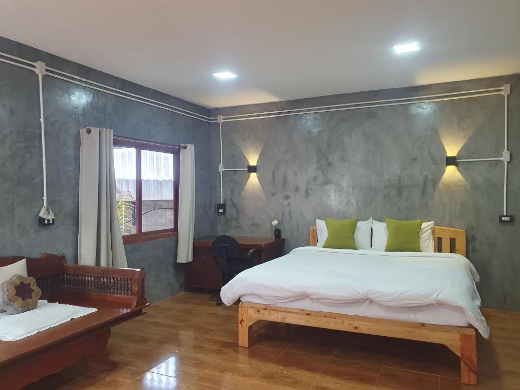 a bedroom with a large white bed and a window at Mind's Homestay มายด์โฮมสเตย์ in Kampong Huaibū