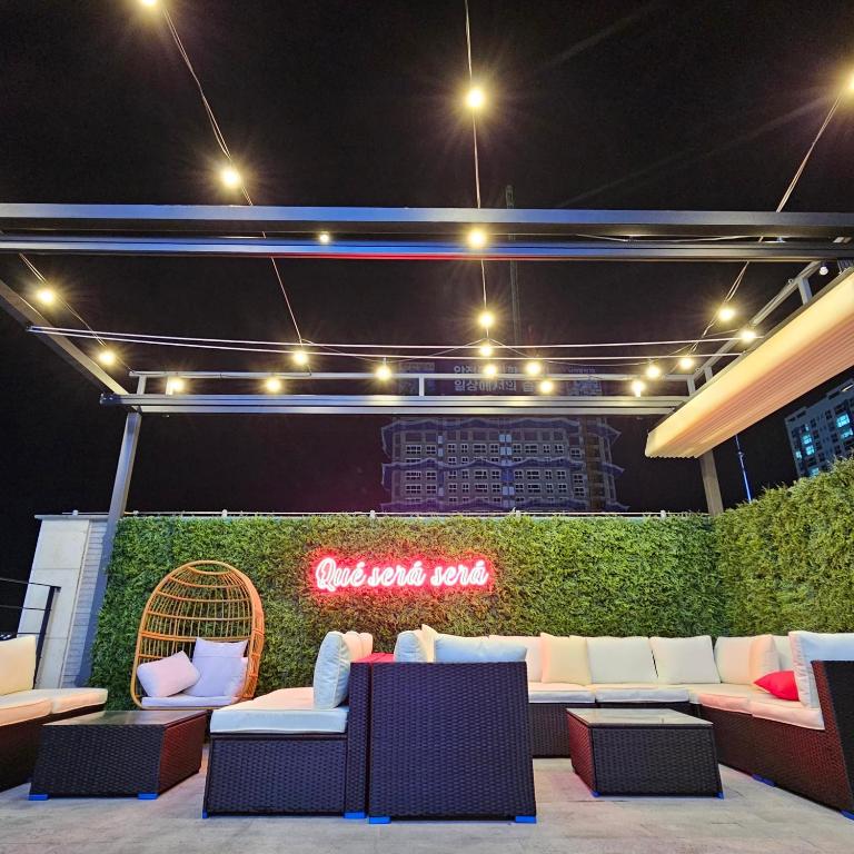 a patio with couches and a neon sign at night at Hound Hotel Mokpo Peace Plaza in Mokpo