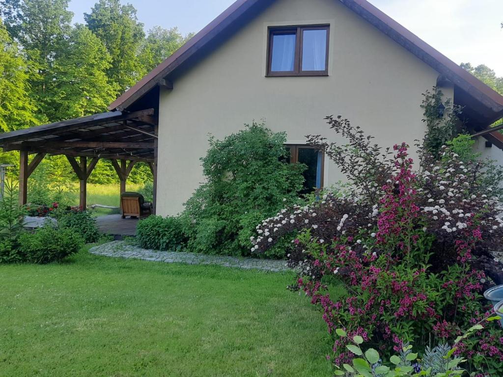 une maison blanche avec un bouquet de fleurs dans la cour dans l'établissement Majcia, à Jelenia Góra