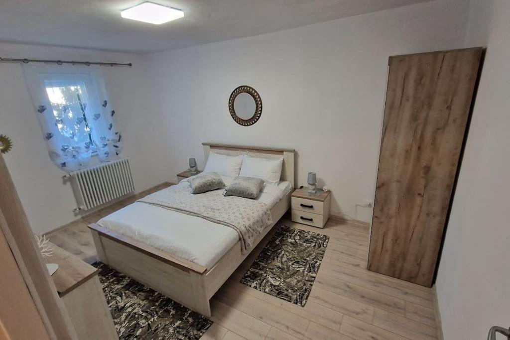1 dormitorio con cama y espejo en la pared en Apartament Coco, en Codlea