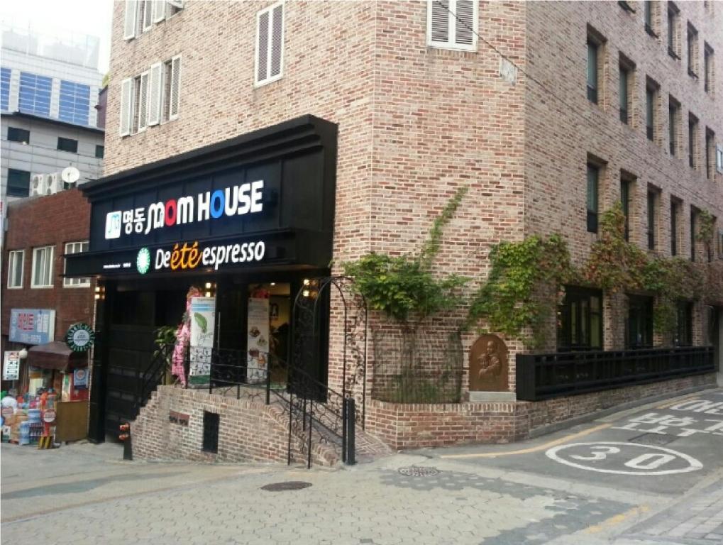 
a large brick building with a sign on the side of it at Myeongdong Mom House in Seoul
