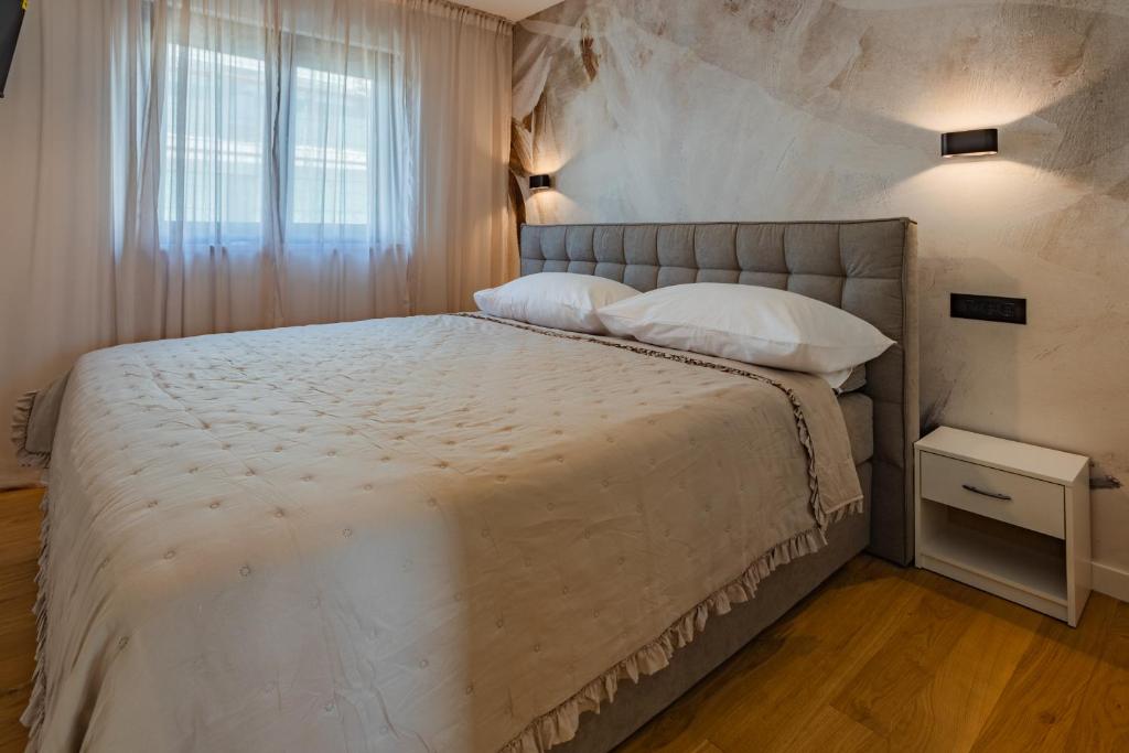 una camera con un grande letto e una finestra di Karmen Luxury Apartments Borik a Zara (Zadar)