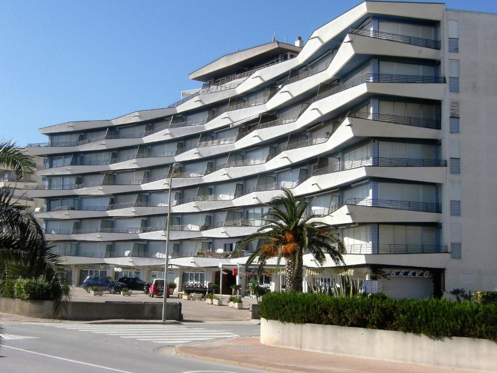 een groot appartementencomplex met een palmboom ervoor bij Catalonia 1-7 in L'Estartit