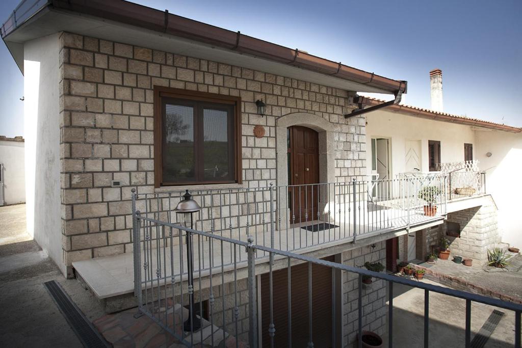 ein Backsteinhaus mit einem Balkon und einer Tür in der Unterkunft B&b Il Gheppio in Campolattaro
