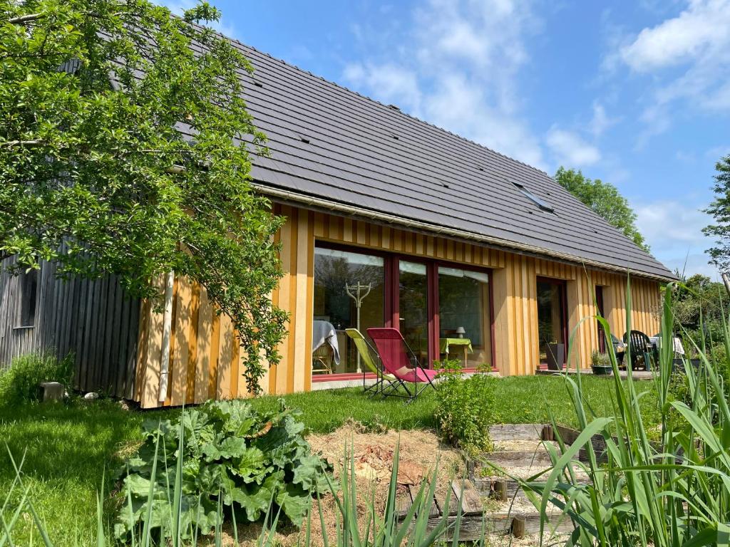 une maison avec beaucoup de fenêtres dans une cour dans l'établissement Chambre d'hôtes de Paille et d'Argile, à Touligny