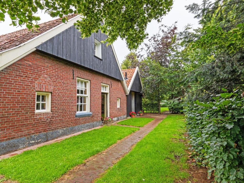 een stenen huis met een grasveld naast een gebouw bij Cozy Apartment in Enschede near Forest in Enschede