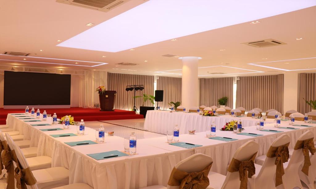 a large banquet hall with white tables and chairs at Cam Ranh Riviera Beach Resort & Spa in Cam Ranh