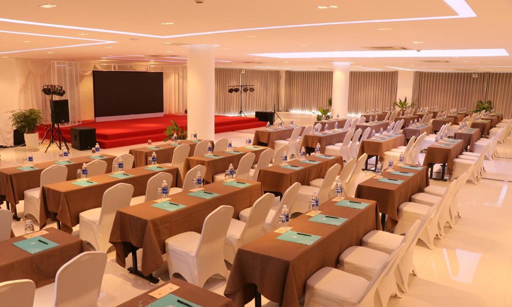 a banquet hall with tables and chairs and a screen at Cam Ranh Riviera Beach Resort & Spa in Cam Ranh
