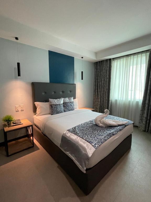 a bedroom with a large bed and a table at Homes at Bay Area Suites by SMS Hospitality in Manila
