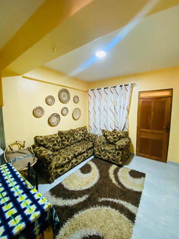a living room with a couch and a rug at Qarib Rock City in Mwanza