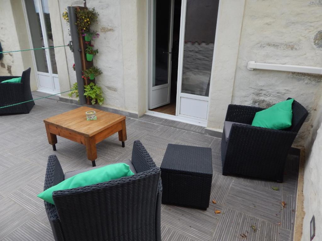 un patio con sillas, una mesa y una puerta en Chambre d'Hôtes le massanous, en Laure-Minervois