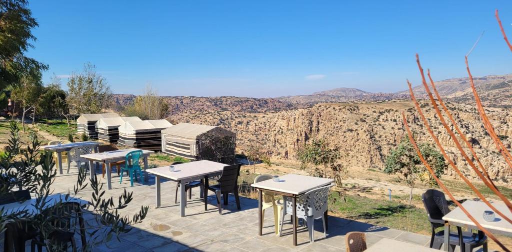 grupa stołów i krzeseł z widokiem na góry w obiekcie Al-Nawatef ECO camp- Dana Nature Reserve w mieście Dana