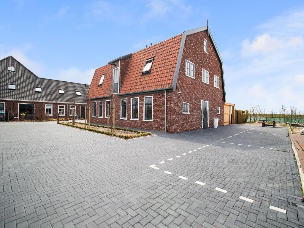een bakstenen gebouw met een parkeerplaats ervoor bij Spacious holiday home Hazenborgh in Callantsoog near beach in Callantsoog