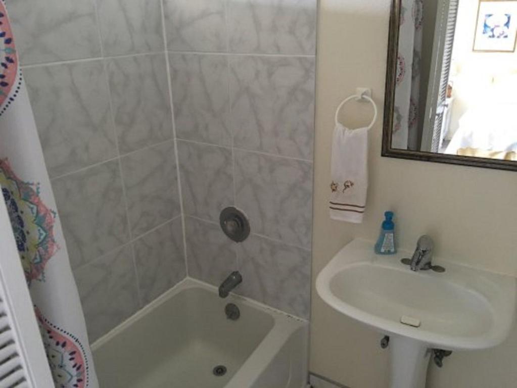 a bathroom with a sink and a tub and a shower at Hale-Hoola B & B in Captain Cook