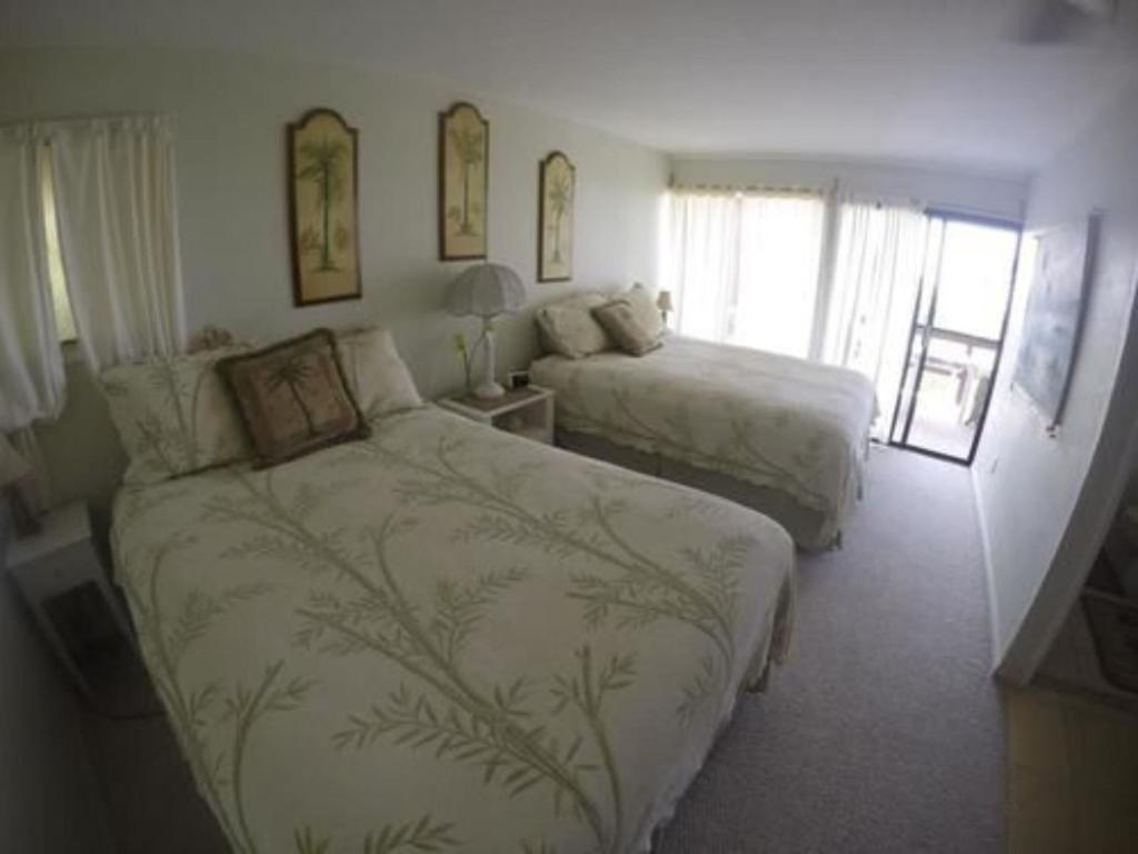 a hotel room with two beds and a window at Hale-Hoola B & B in Captain Cook