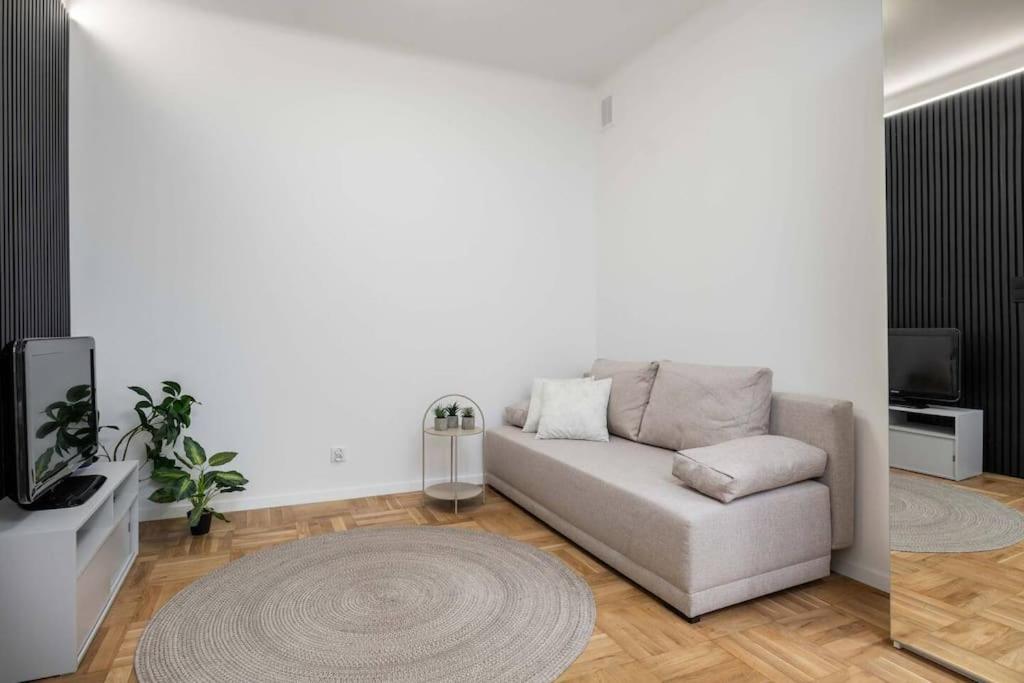 a living room with a couch and a rug at Vanilla Apartment Ochota in Warsaw
