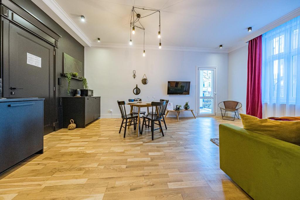uma cozinha e sala de estar com mesa e cadeiras em Apartamenty House Managers - Bursztynowa Zatoka em Sopot