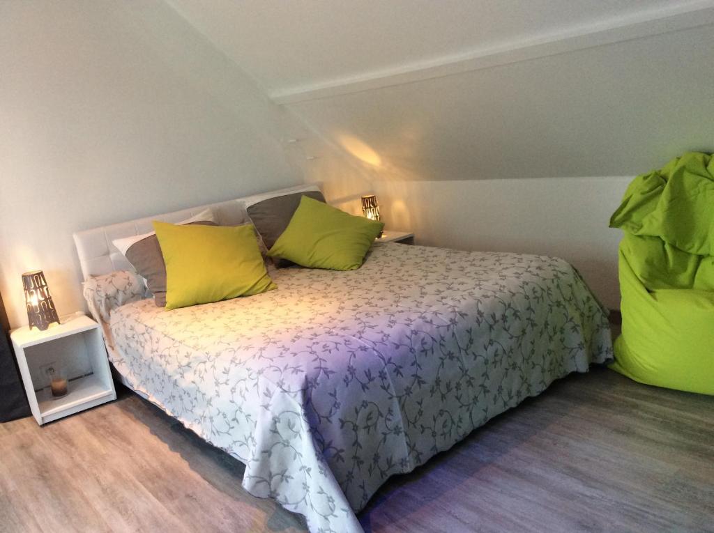 a bedroom with a bed with yellow and green pillows at Jardin Des Énigmes in Boissay