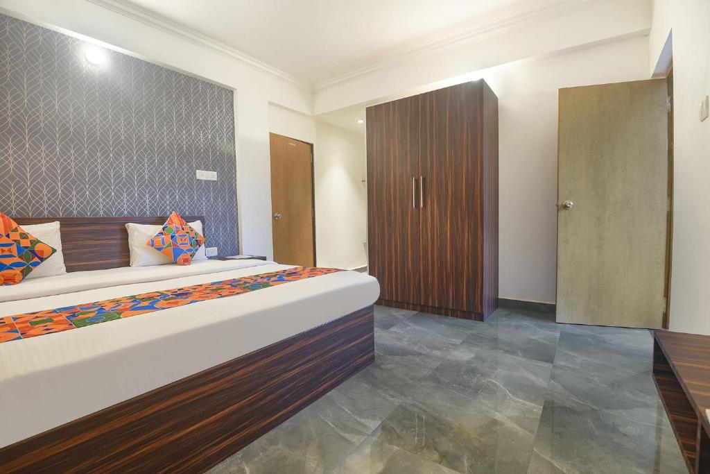 - une chambre avec un grand lit et une armoire en bois dans l'établissement FabExpress MA Homes, à Morjim