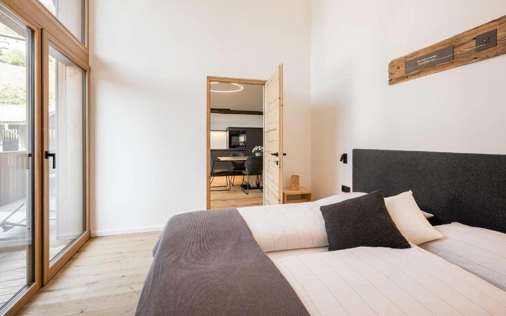 - une chambre avec un grand lit et un salon dans l'établissement Bachmannhof Apartment Ringelblume, à Velturno