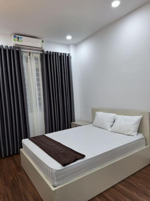Schlafzimmer mit einem großen Bett und schwarzen Vorhängen in der Unterkunft Căn Hô Tại Bùi Viện in Ho-Chi-Minh-Stadt