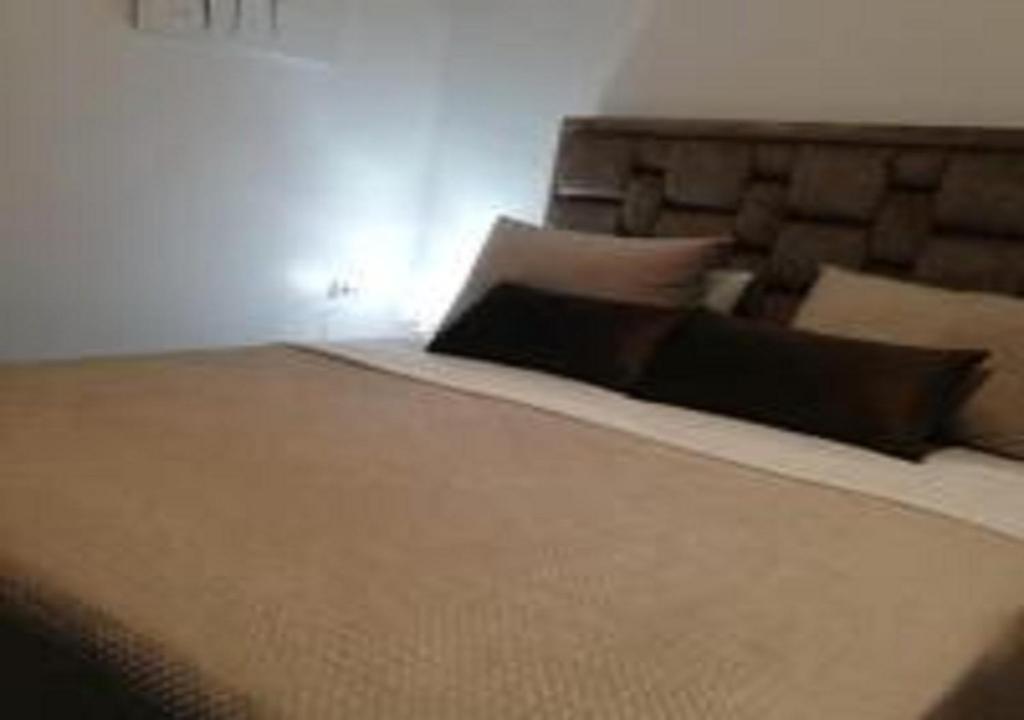 Appart Hôtel Tanger Paname في طنجة: غرفة نوم مع سرير كبير مع وسائد سوداء
