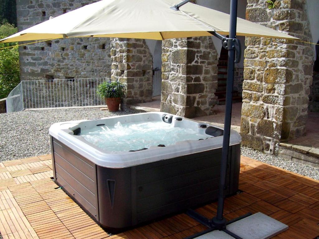 Casola in LunigianaにあるFlat with heated hot tub and shared poolの- ホットタブ(パラソル付きのデッキ付)