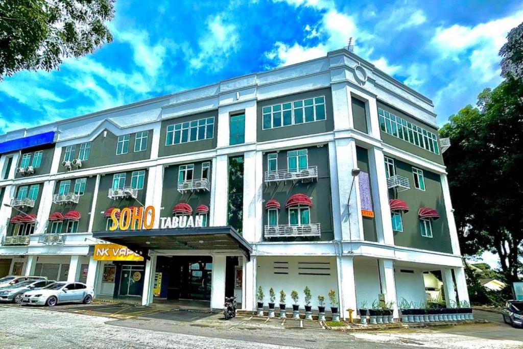 un grand bâtiment avec des auvents rouges dans une rue dans l'établissement Soho Tabuan Kuching, à Kuching