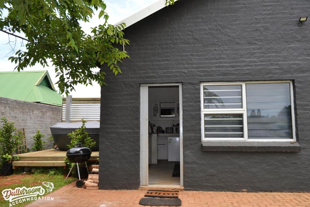 a black house with a kitchen and a window at Clarky's Bucketlist in Dullstroom