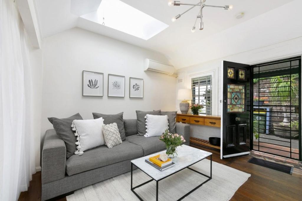 sala de estar con sofá y mesa en Paddington Garden Cottage with fast Wifi en Sídney