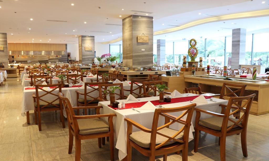 a dining room with tables and chairs in a restaurant at Cam Ranh Riviera Beach Resort & Spa in Cam Ranh