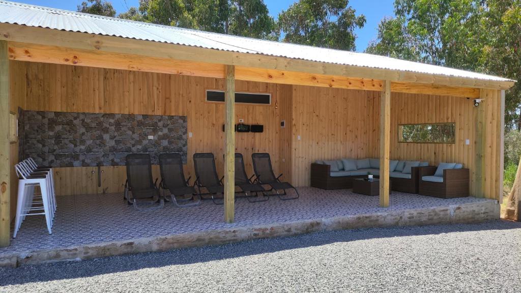 Cabaña 4-6 personas con piscina في ألغاروبو: جناح مع كراسي وسرير وطاولة