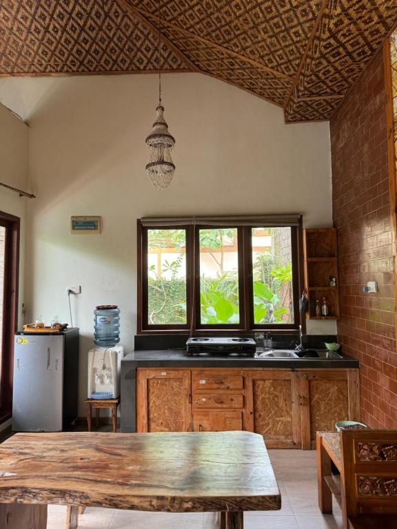 a kitchen with a wooden table and a window at Calmness Villa Syariah in Sekupang