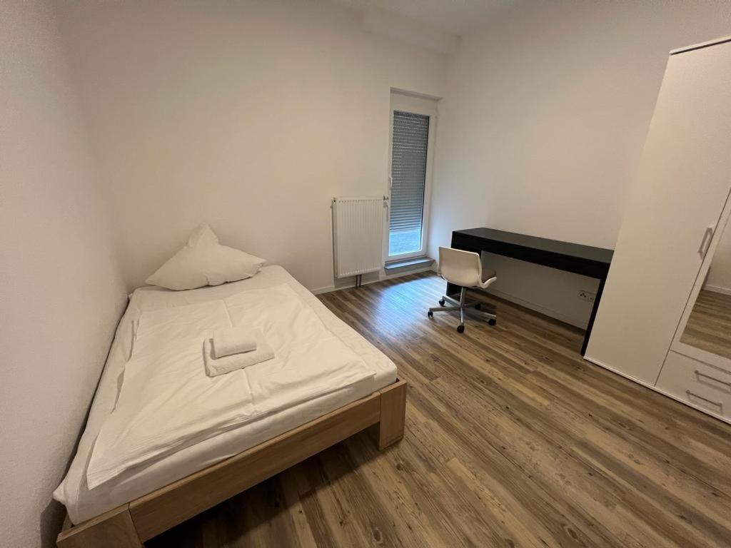 a bedroom with a bed and a desk in it at Timeless: 3 Zimmer Maisonette-Wohnung in Villingen-Schwenningen in Villingen-Schwenningen