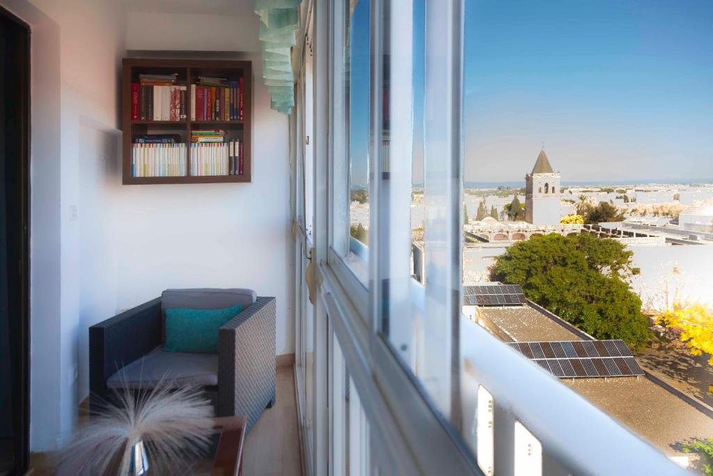 balcón con silla y ventana con vistas en SJE - Shiny apartment close to the river en Sevilla
