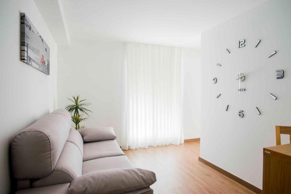 uma sala de estar com um sofá e um relógio na parede em Hotel Gastronómico Gandainas em Riós