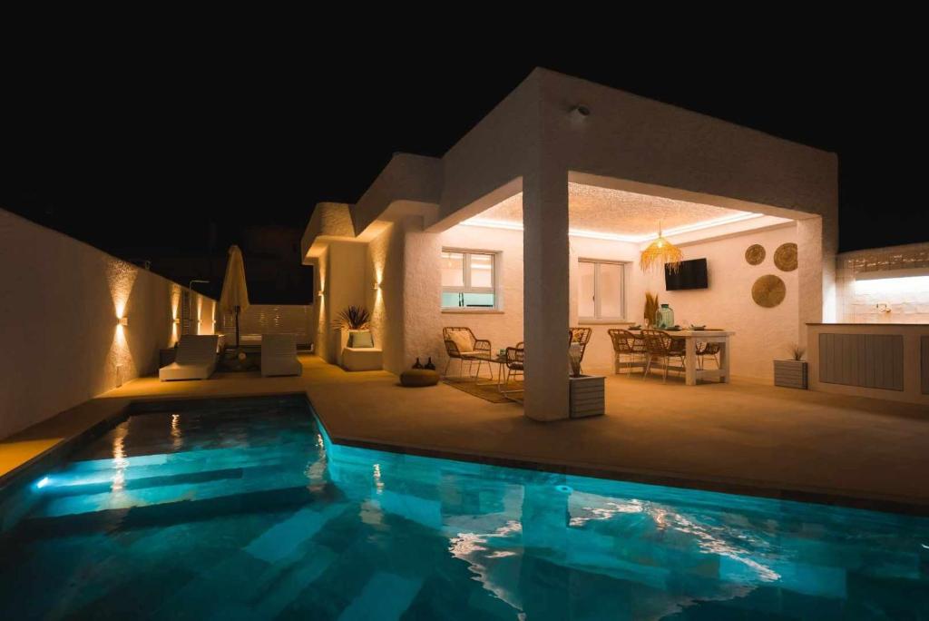 a house with a swimming pool at night at Casa Islandia en Riumar ( a 100m de la playa ) in Riumar