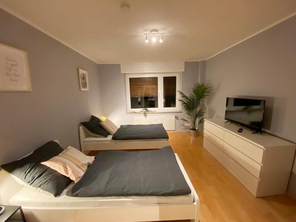 uma sala de estar com uma cama e uma televisão em Monteurwohnung Neuss em Neuss
