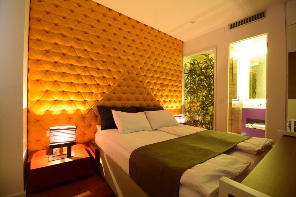 1 dormitorio con 1 cama grande y pared de color naranja en Boutique Rooms, en Belgrado