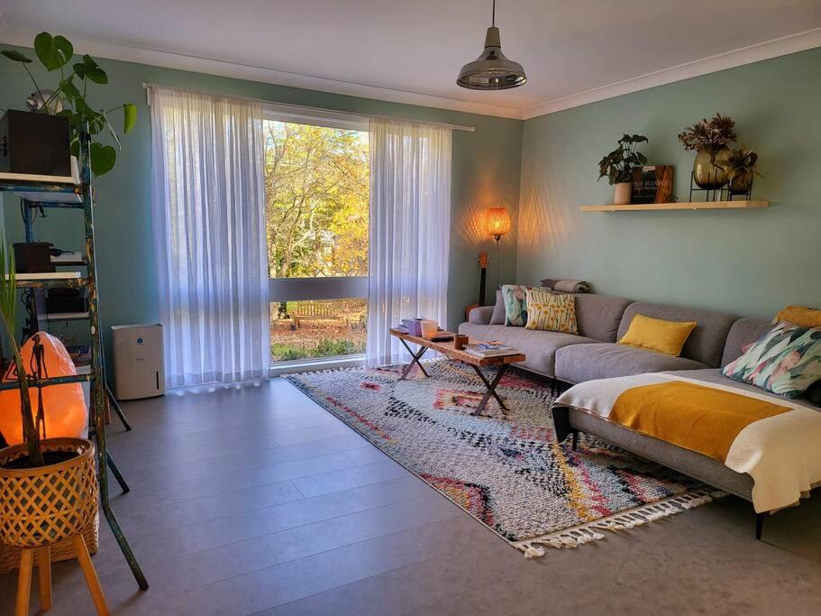 ein Wohnzimmer mit einem Sofa und einem Tisch in der Unterkunft The Yellow Koala - Vibrant Home in Medlow Bath in Medlow Bath
