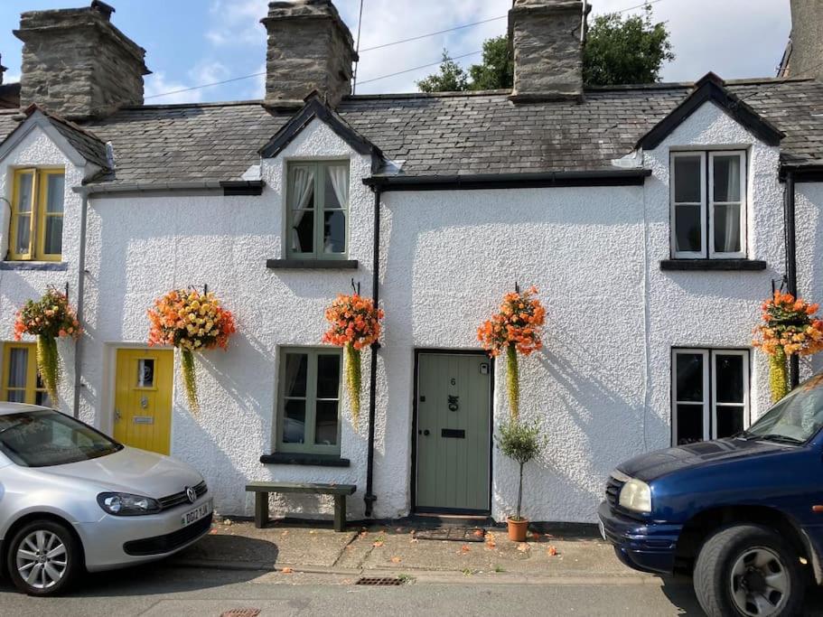 a white house with a car parked in front of it at Lovely peaceful 2 bed cottage in Llandderfel