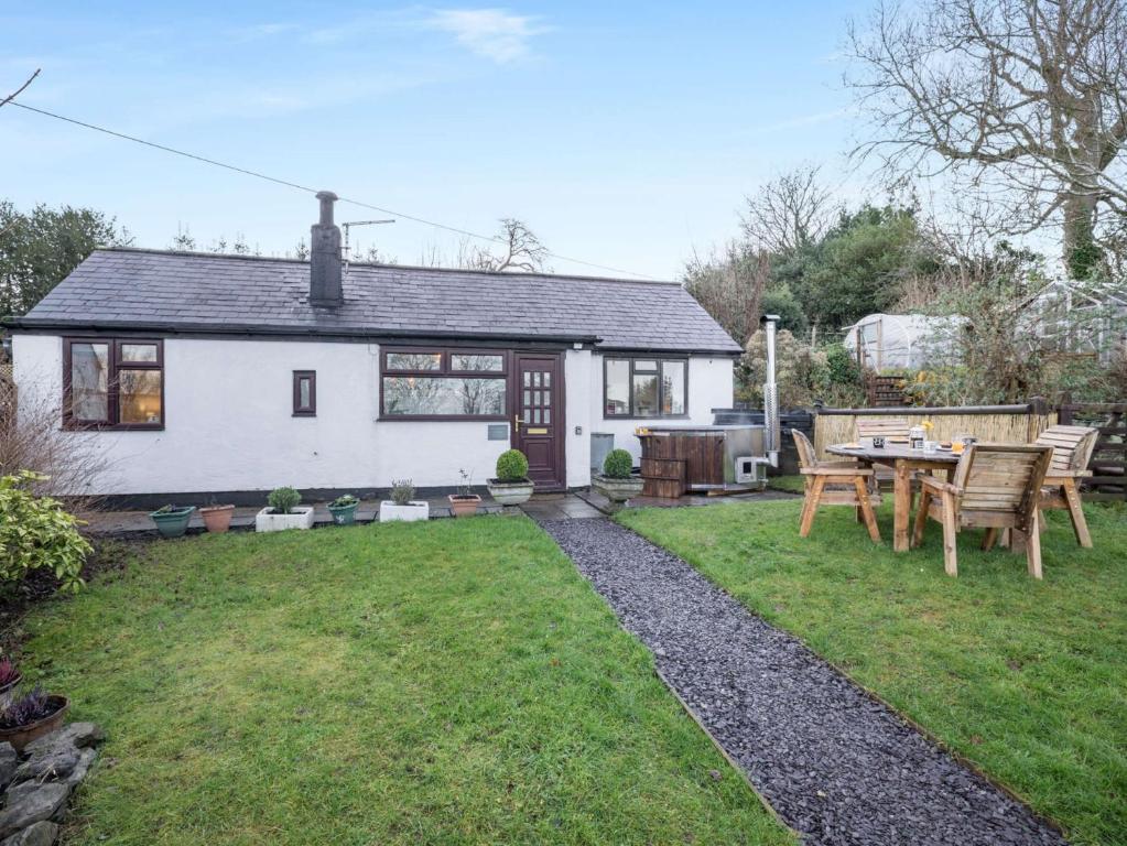 een huis met een tafel en stoelen in een tuin bij 2 bed in Denbigh 90461 in Caerwys