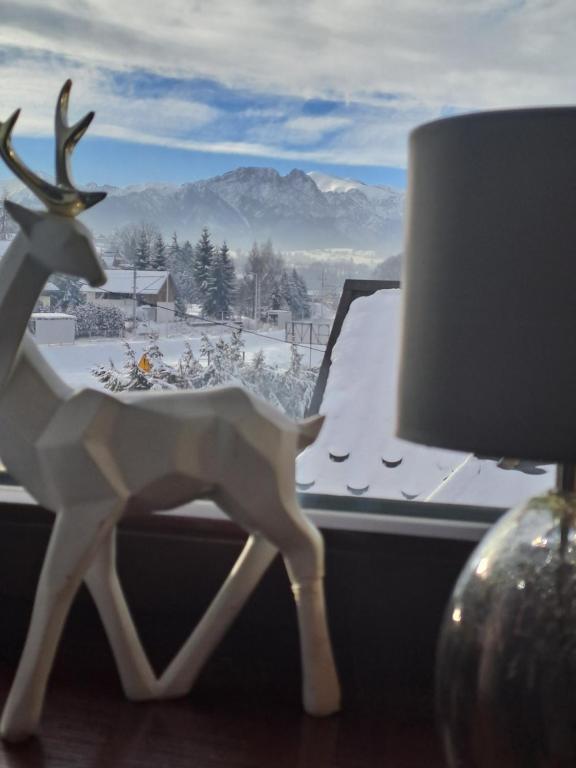 a figurine of a reindeer standing in front of a window at Pokoje gościnne U Paliderki in Poronin