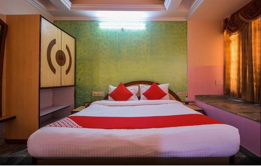 ein Schlafzimmer mit einem großen Bett mit roten Kissen in der Unterkunft Pax in hotel in Udaipur